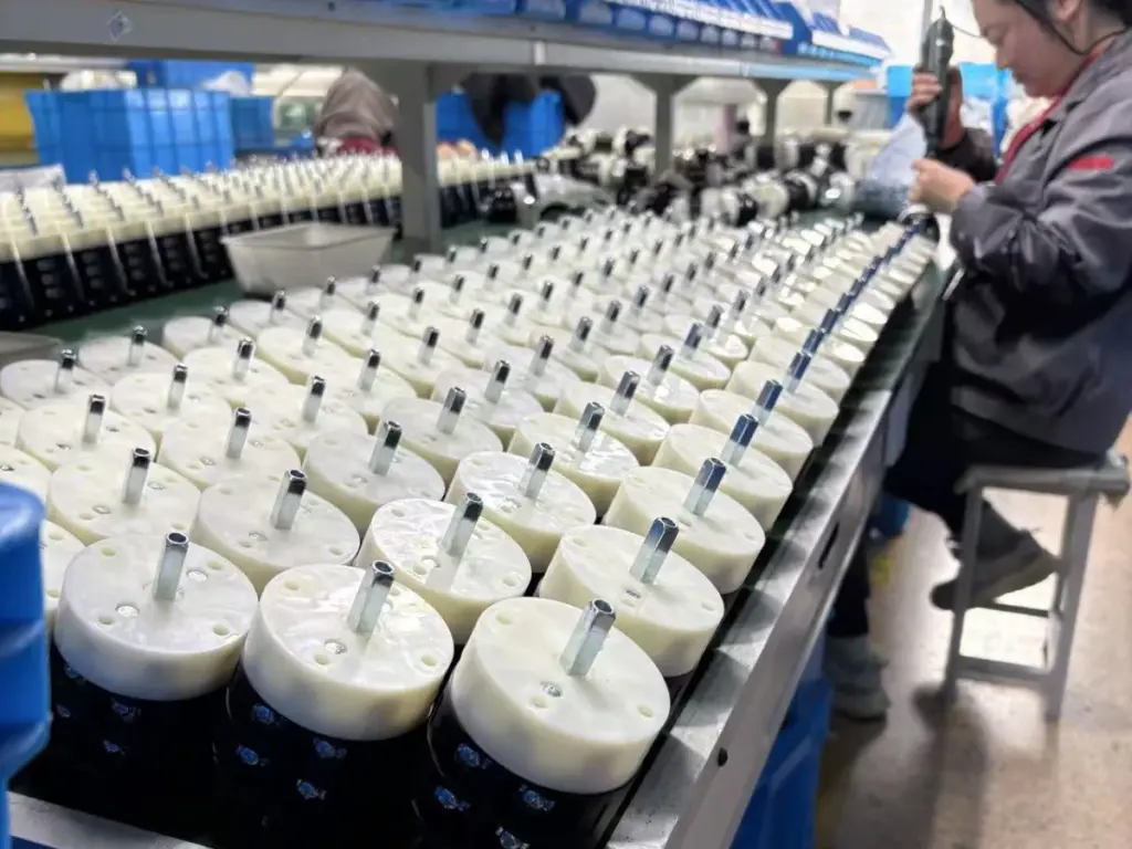 VIOX workshop operator assembling rotary cam switches at the production bench